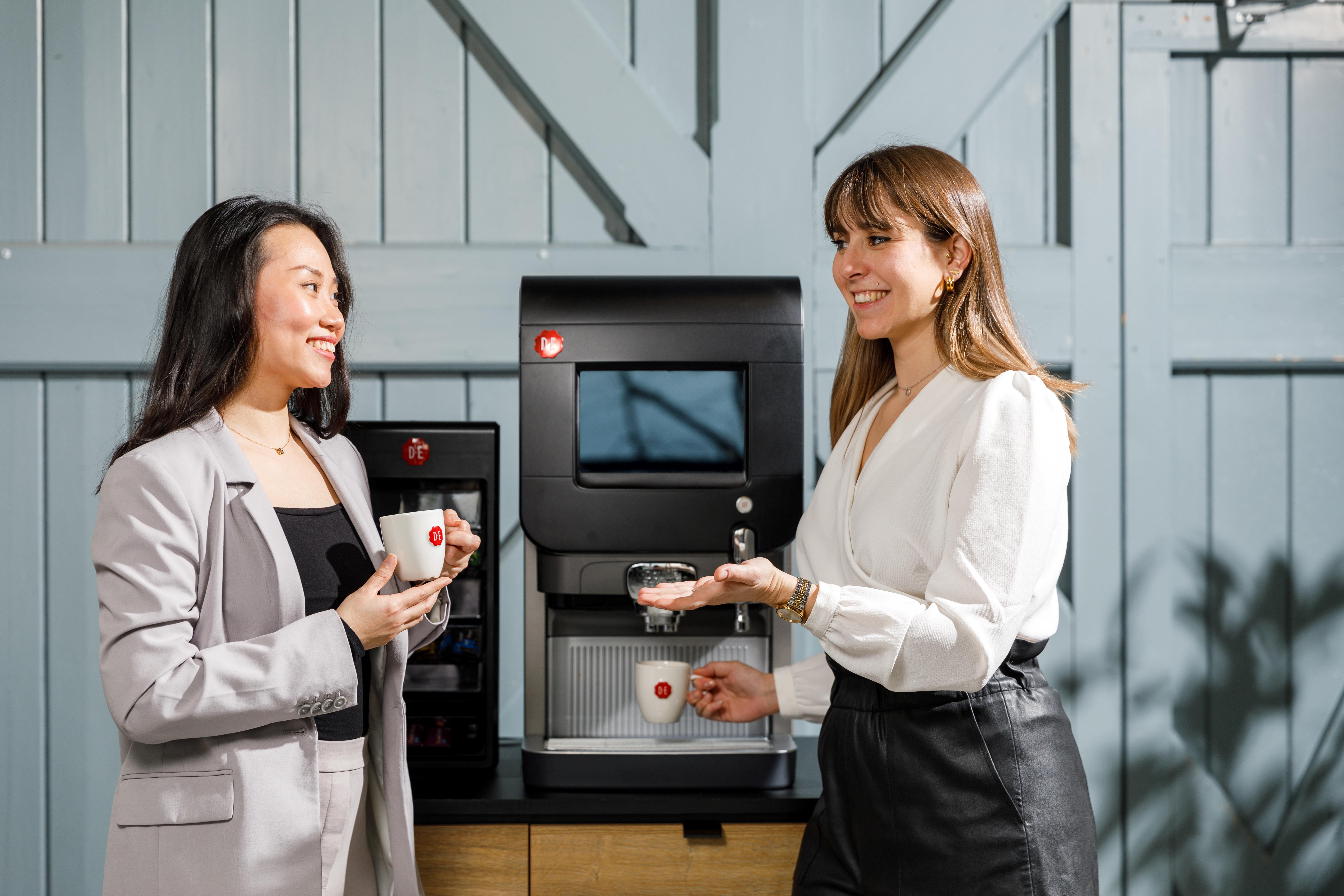 Two people at a coffee machine