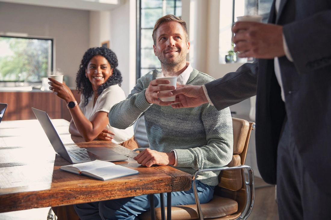 Colleagues drinking coffee in a meeting room