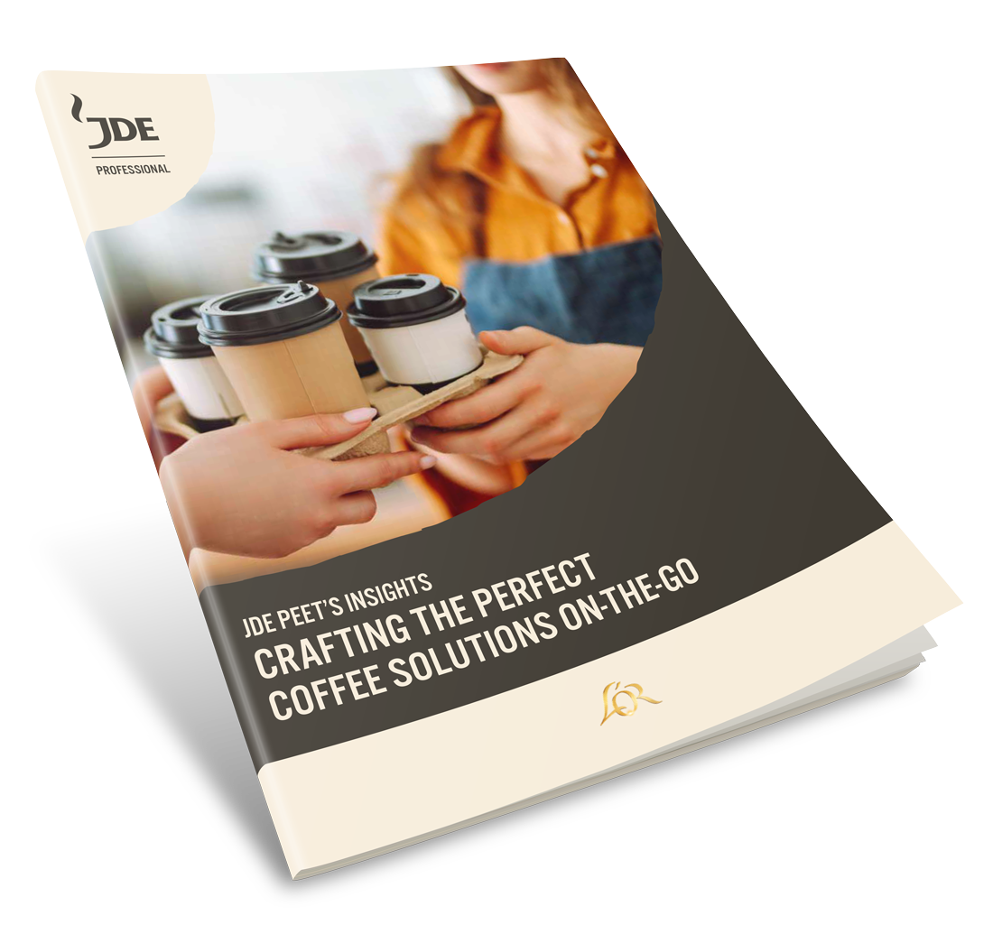 Person digging two hands into a pile of coffee beans and filling their palms with coffee beans and lifting them up